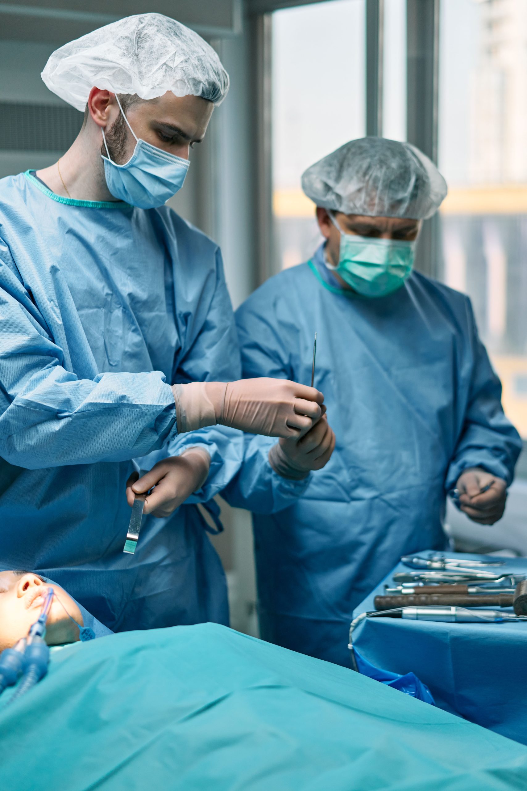 Two surgeons in an operating room performing a surgery under sterile conditions.